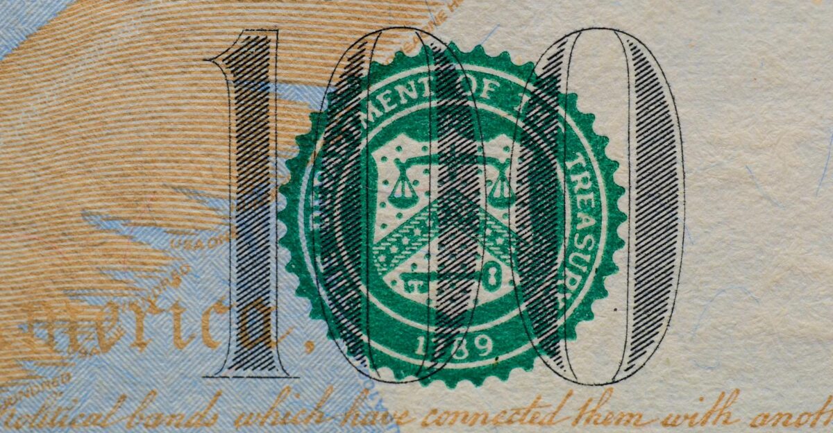 Detailed view of the US 100 dollar bill showing the Treasury seal and printed text