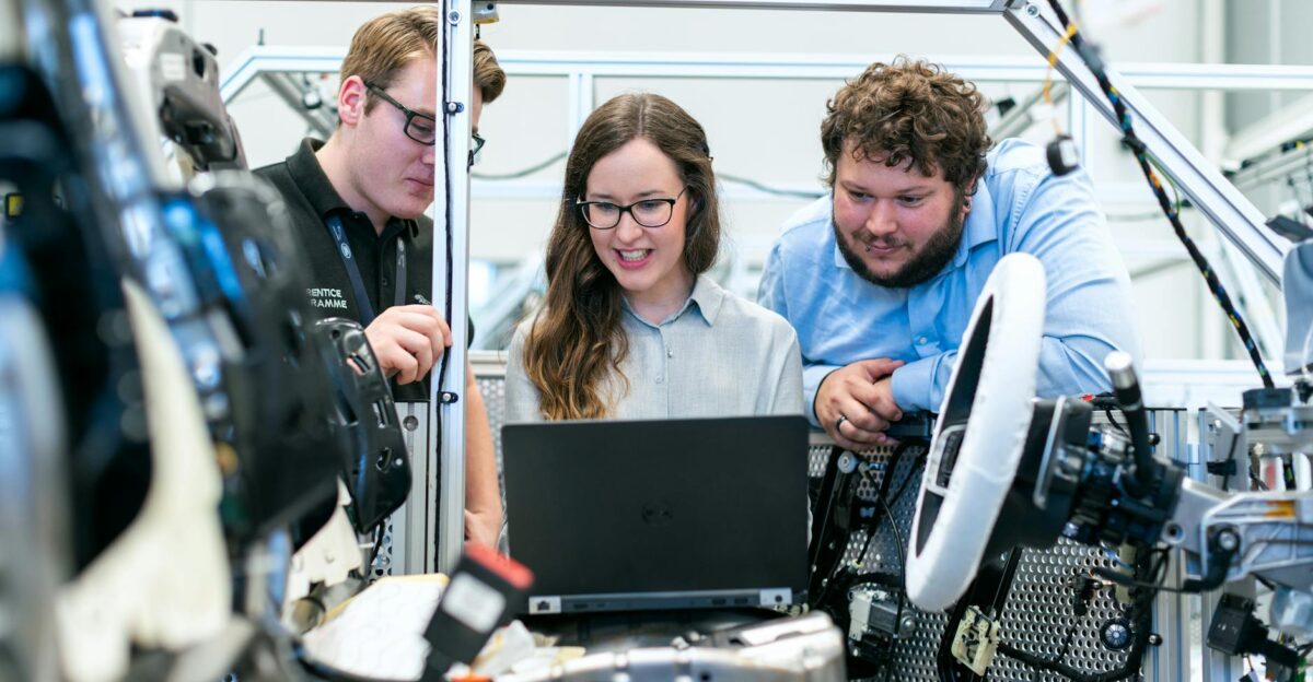 Engineers collaborating on a car project in a modern automotive workshop using advanced technology