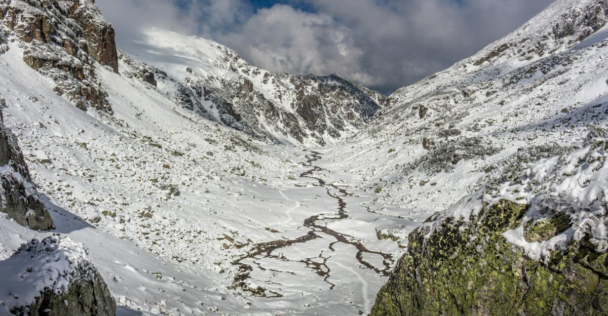 A breathtaking view of a snowy mountain valley under a clear sky
