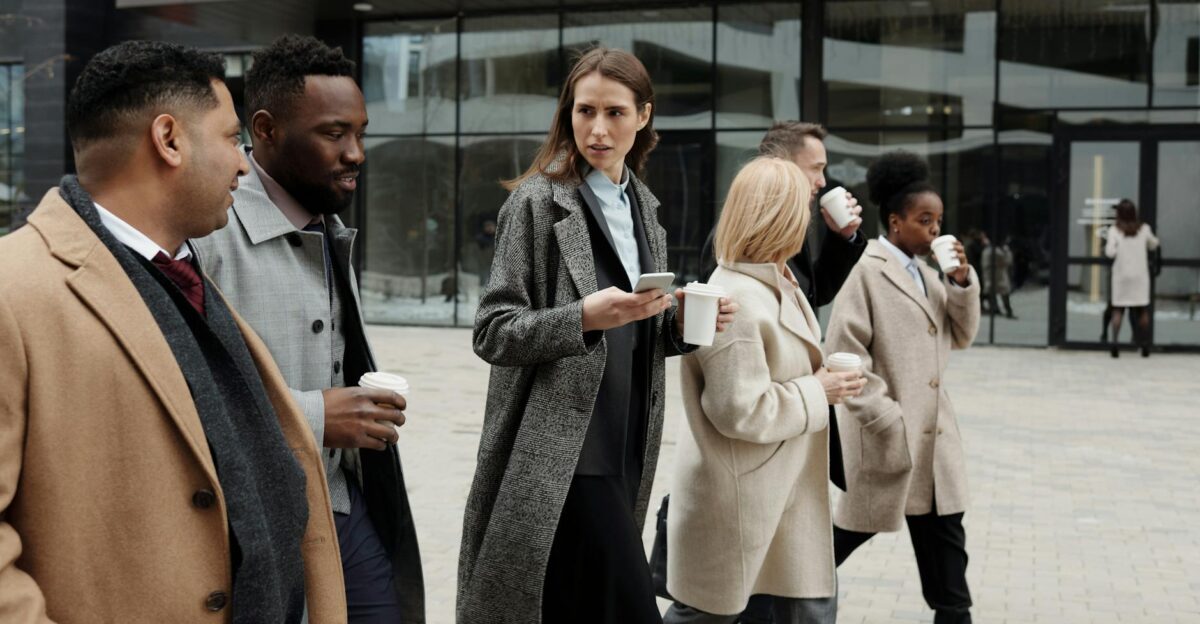 A group of diverse business professionals enjoying a coffee break outdoors in the city