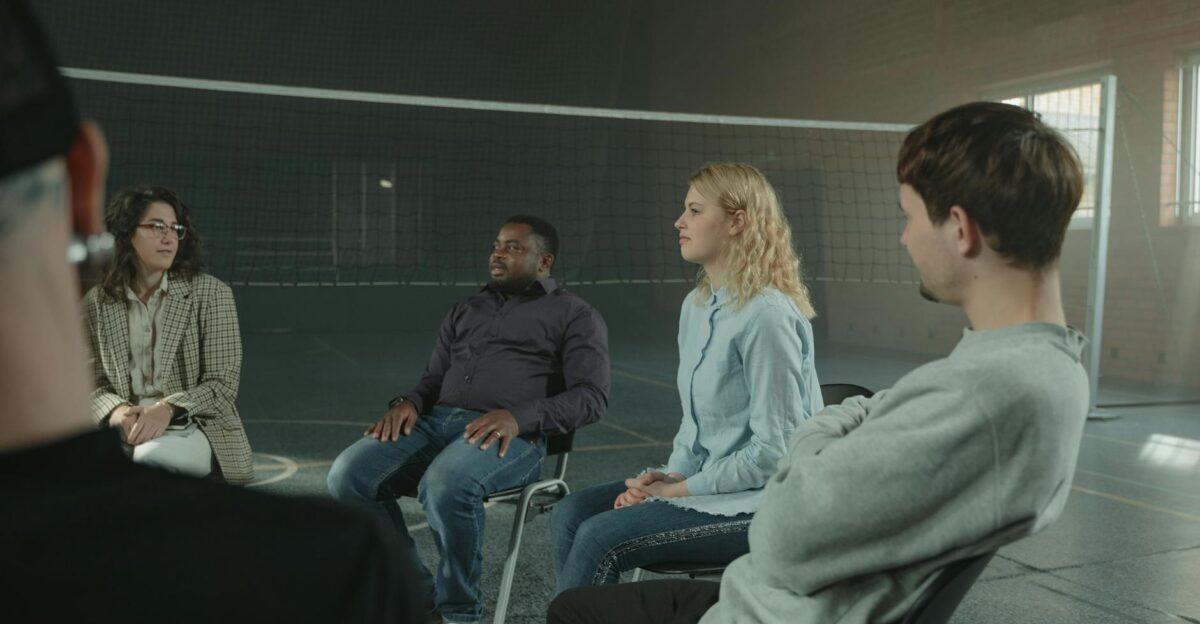 Diverse group of adults in a supportive indoor discussion setting Sharing experiences