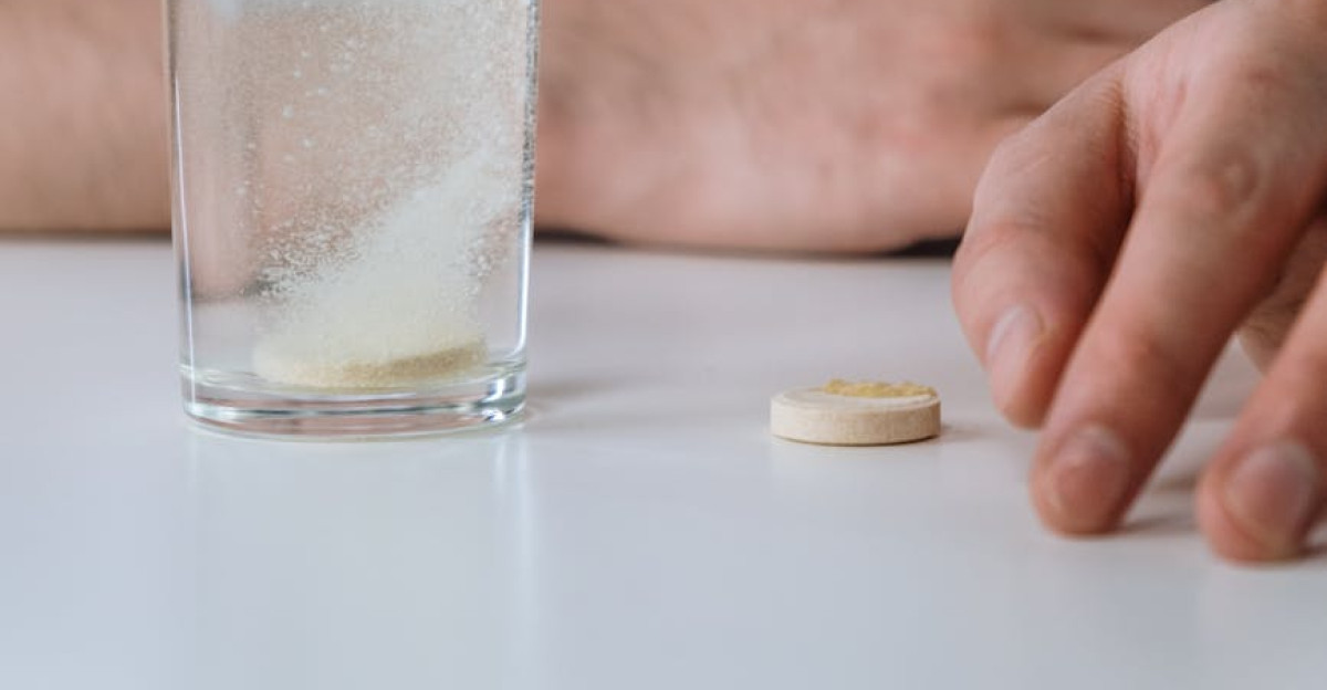 A closer look at an effervescent tablet dissolving in a glass of water creating bubbles