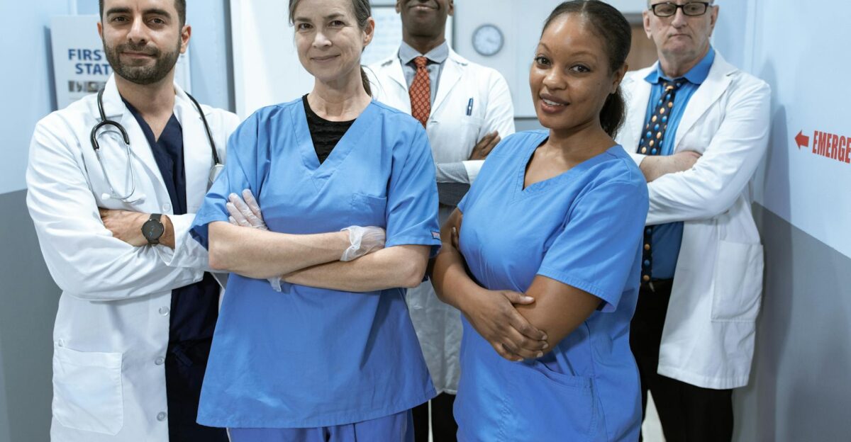 A diverse team of doctors and nurses smiling confidently in a hospital setting