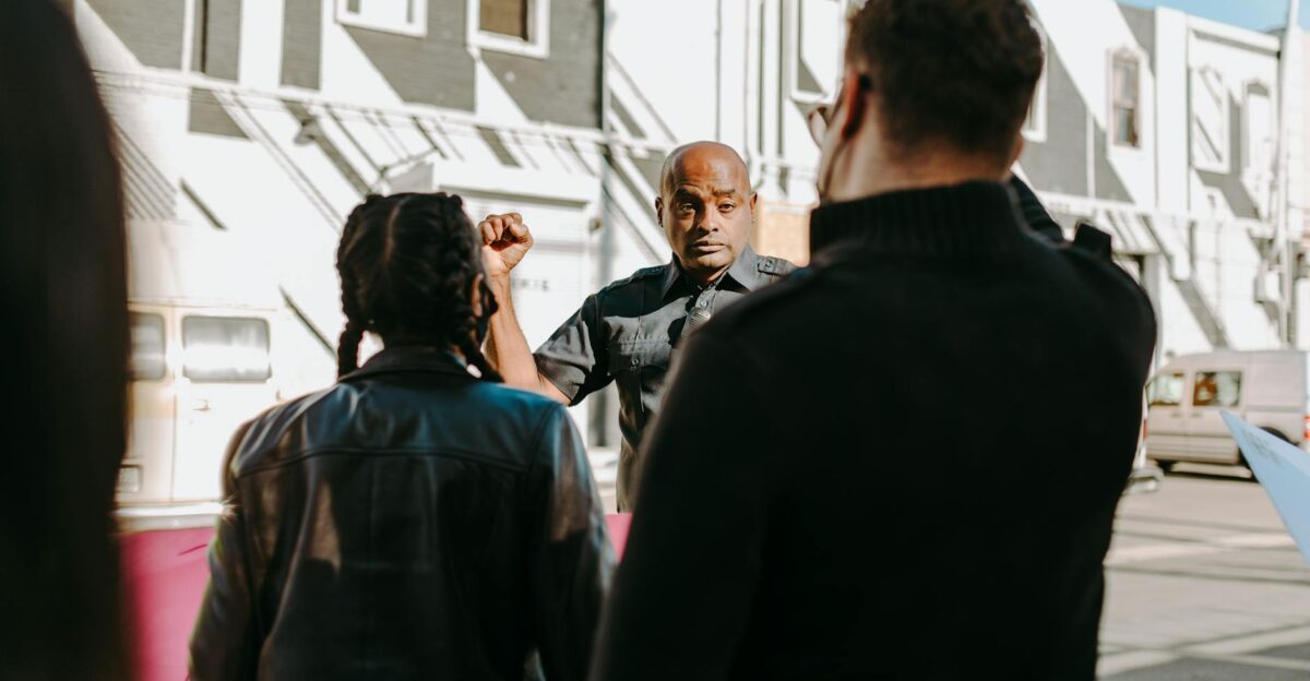 A street scene capturing a policeman interacting with protesters outdoors