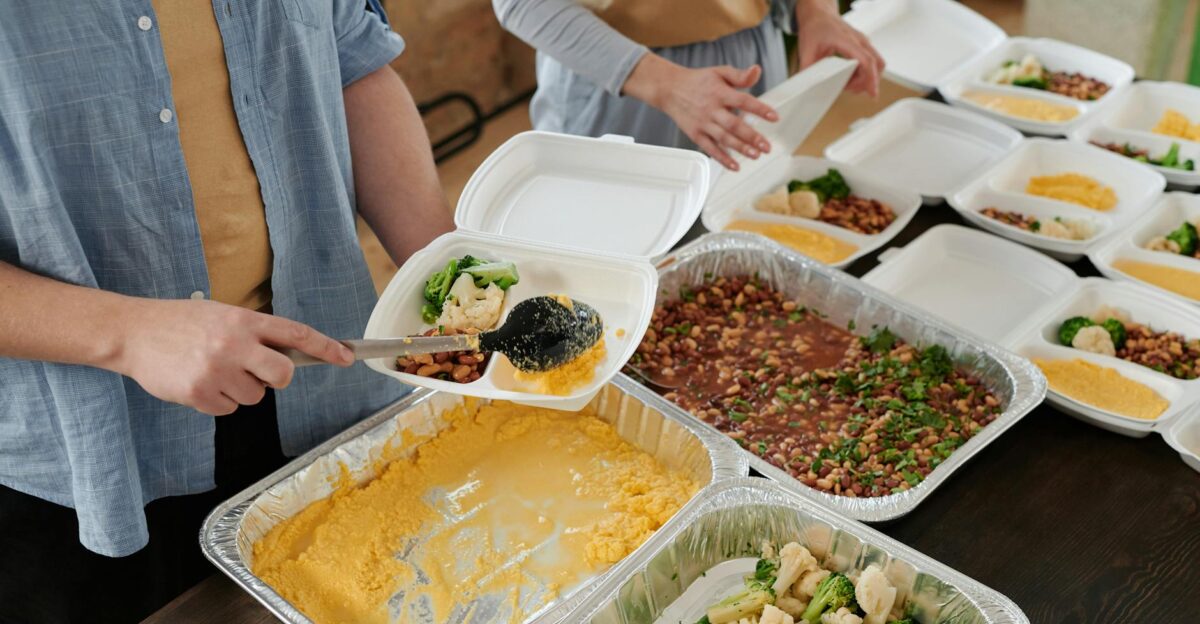Volunteers preparing food packs indoors for donation