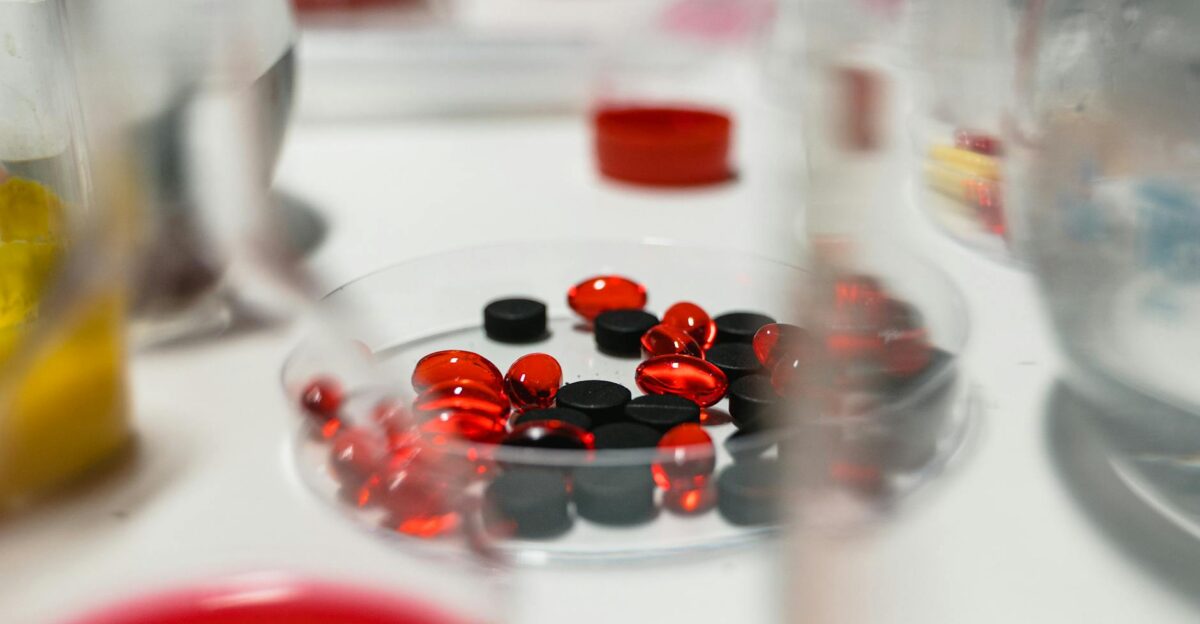 Close-up view of red and black pills on a lab table with blurred background