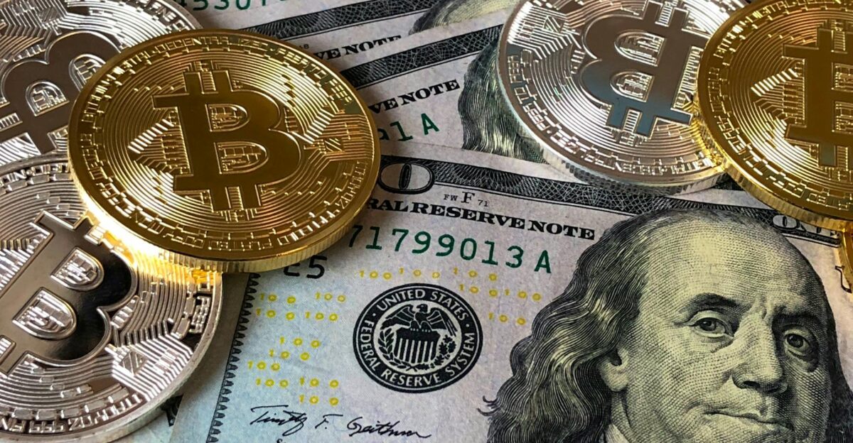 A close-up photo depicting Bitcoin coins on top of US dollar bills symbolizing finance and cryptocurrency
