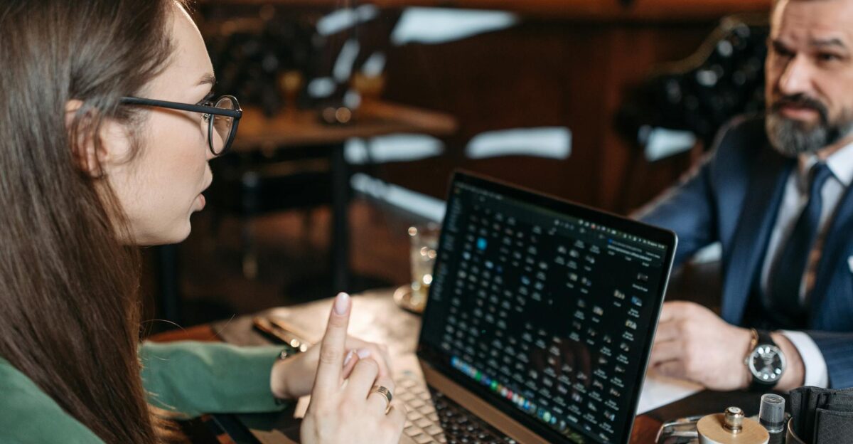 Professional discussion during a business meeting in a restaurant with laptop visible