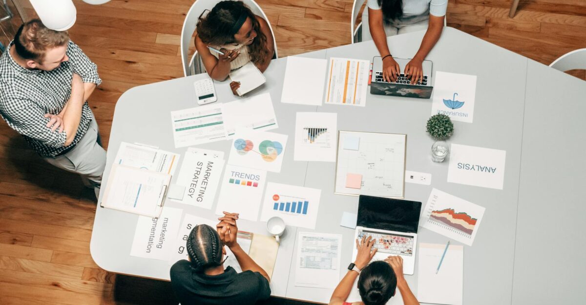 A diverse group working on marketing strategies with charts and laptops in an office setting