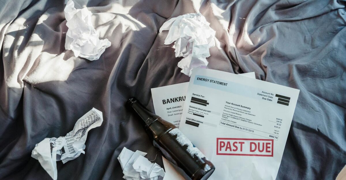 Scene of financial distress with bankruptcy notice past due bills and crumpled papers on a bed
