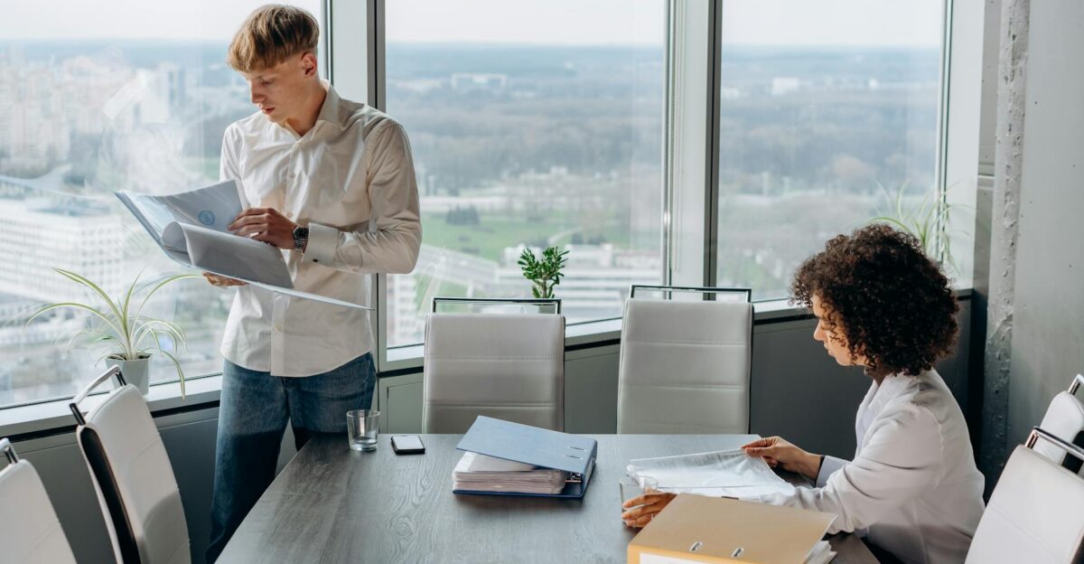 Business professionals reviewing documents in a modern office with city view teamwork and collaboration concept