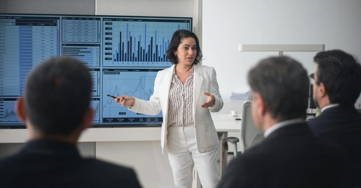 Professional woman presenting stock market data in a modern office setting