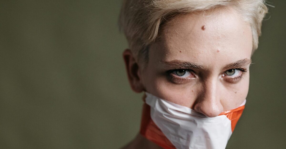 A defiant woman with taped mouth symbolizes silenced voices and human rights