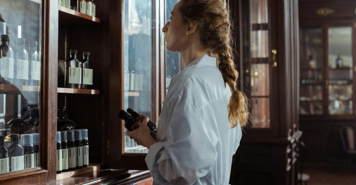 Woman in white coat examines medicine bottles in a vintage pharmacy setting