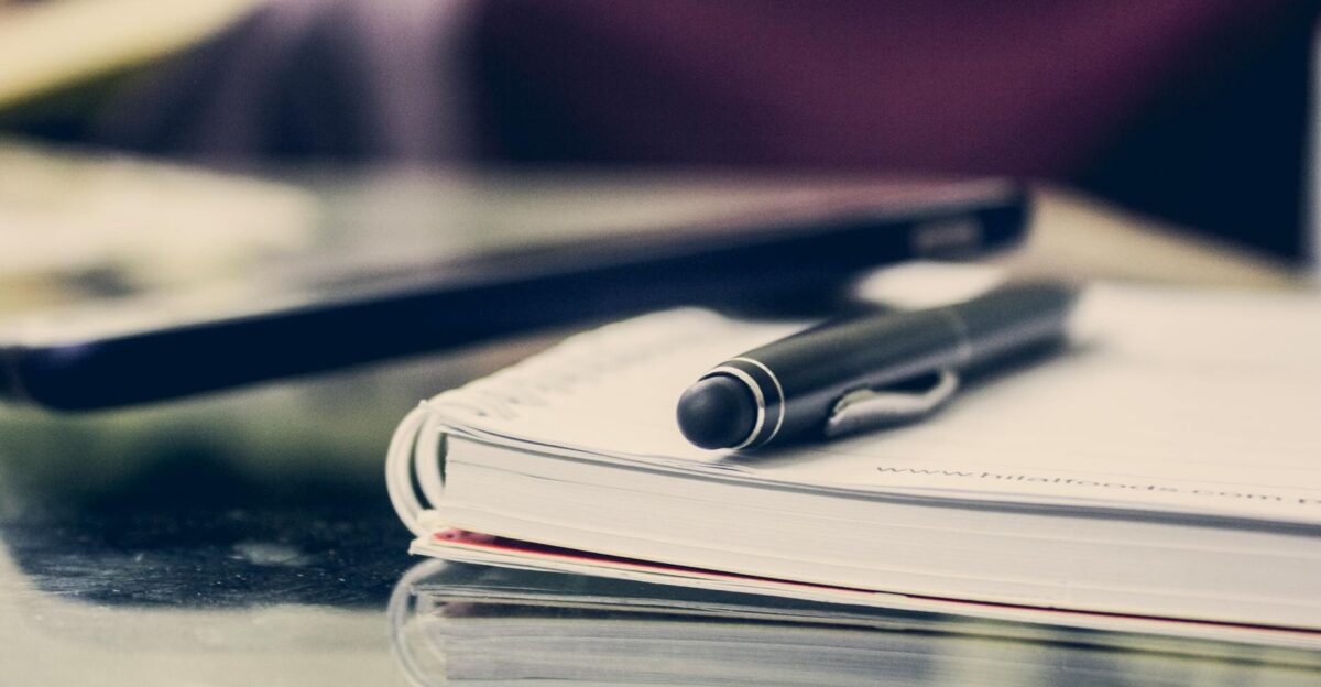 Close-up of an elegant pen resting on an open notebook in a stylish office environment