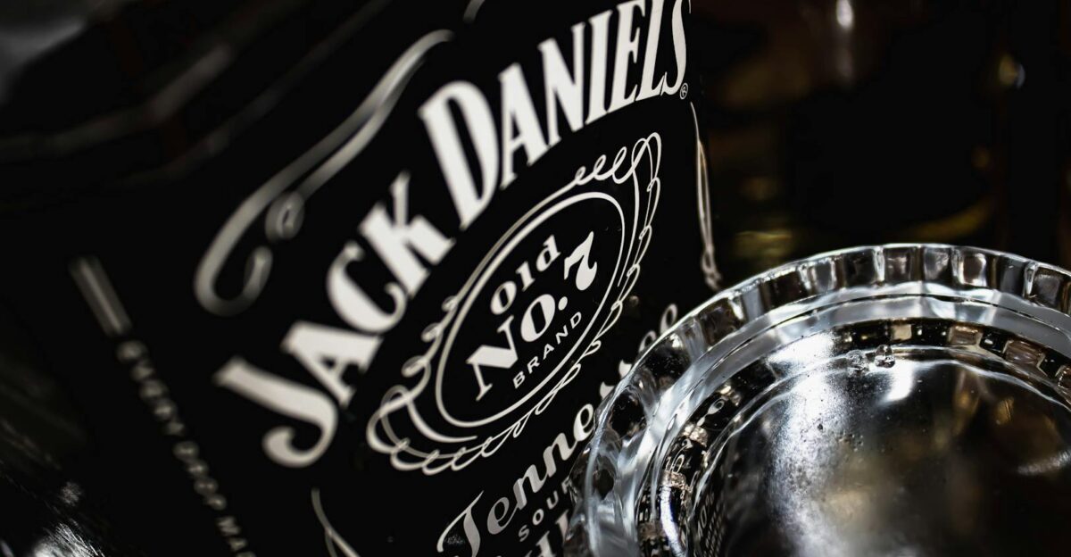 Detailed view of a Jack Daniel s whiskey bottle with glass highlighting the brand s iconic label