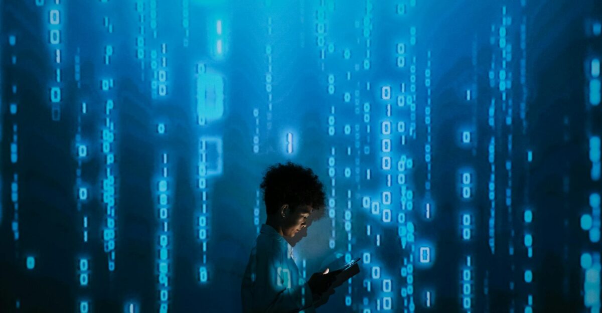 Silhouette of a person using a smartphone surrounded by digital binary code projections
