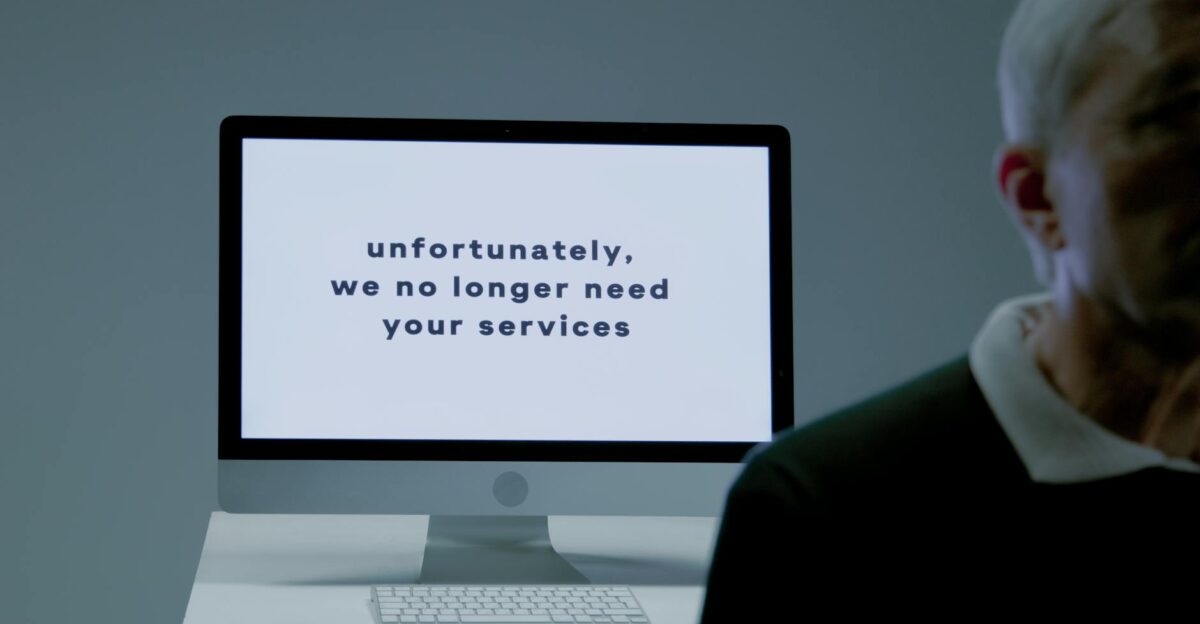 A computer screen displays a termination message indicating job loss or unemployment