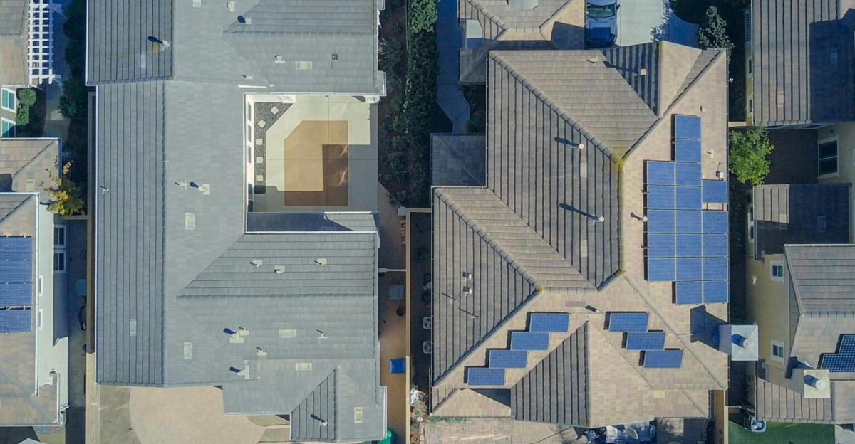 Top-down view of urban houses with solar panels emphasizing clean energy solutions.