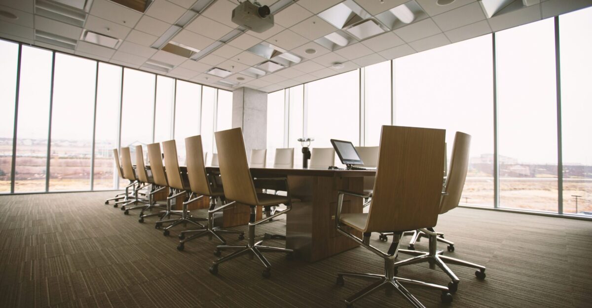 oval brown wooden conference table and chairs inside conference room