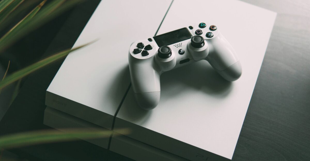 selective focus photography of white Sony PS4 console with wireless controller