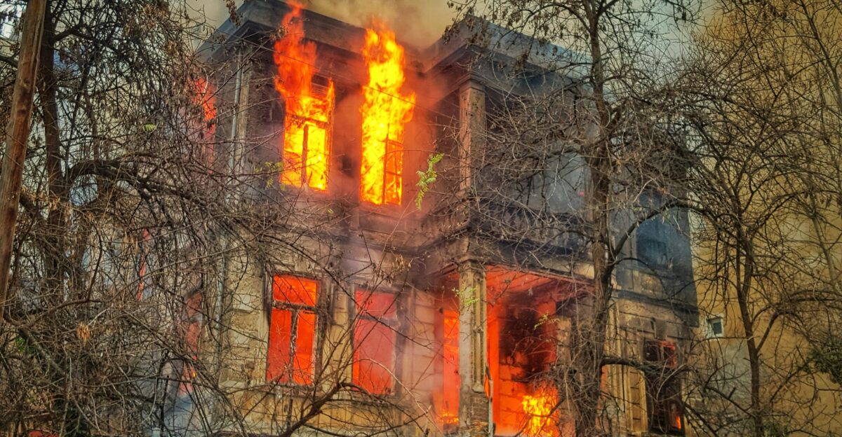 photo of burning house near trees