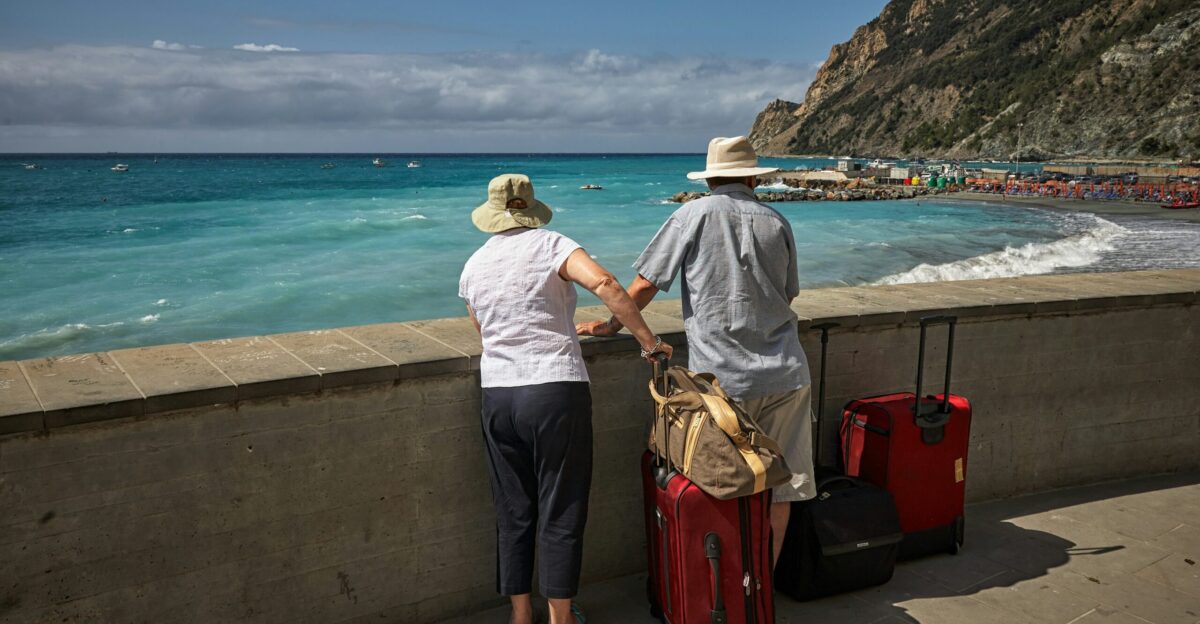 man and woman standing beside concrete seawall looking at beach