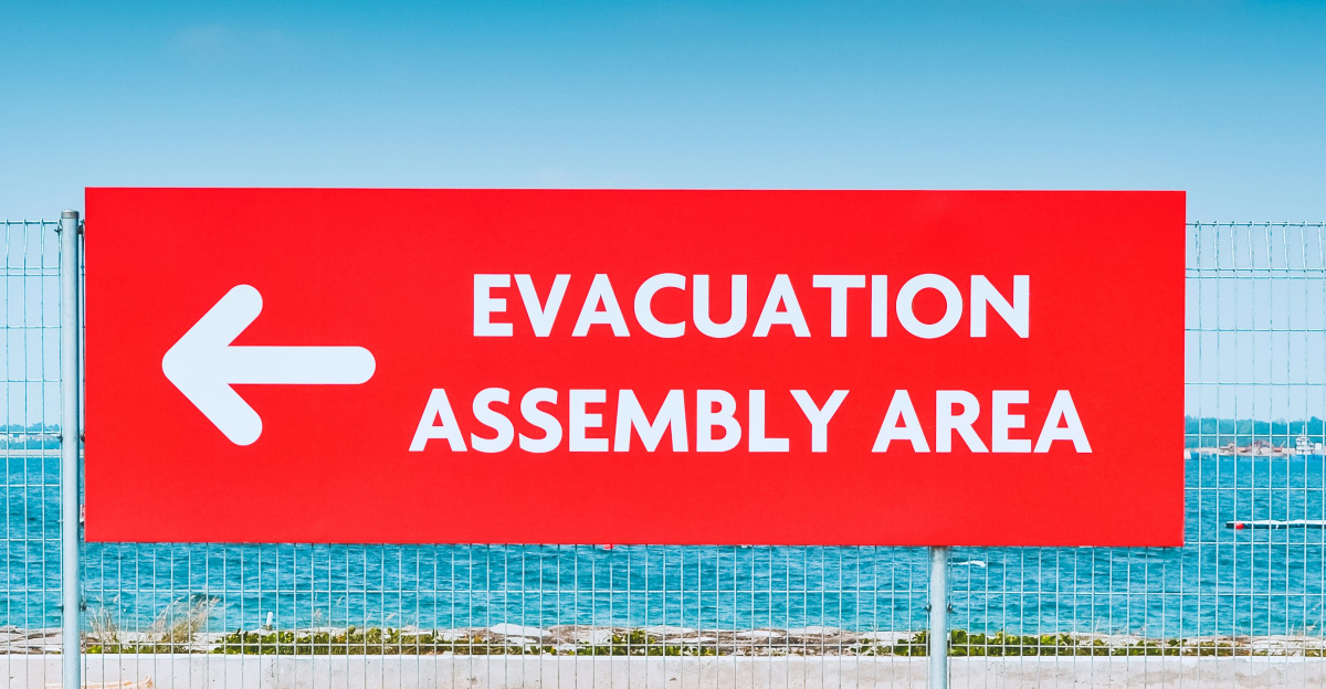man sitting beside the road while holding an umbrella