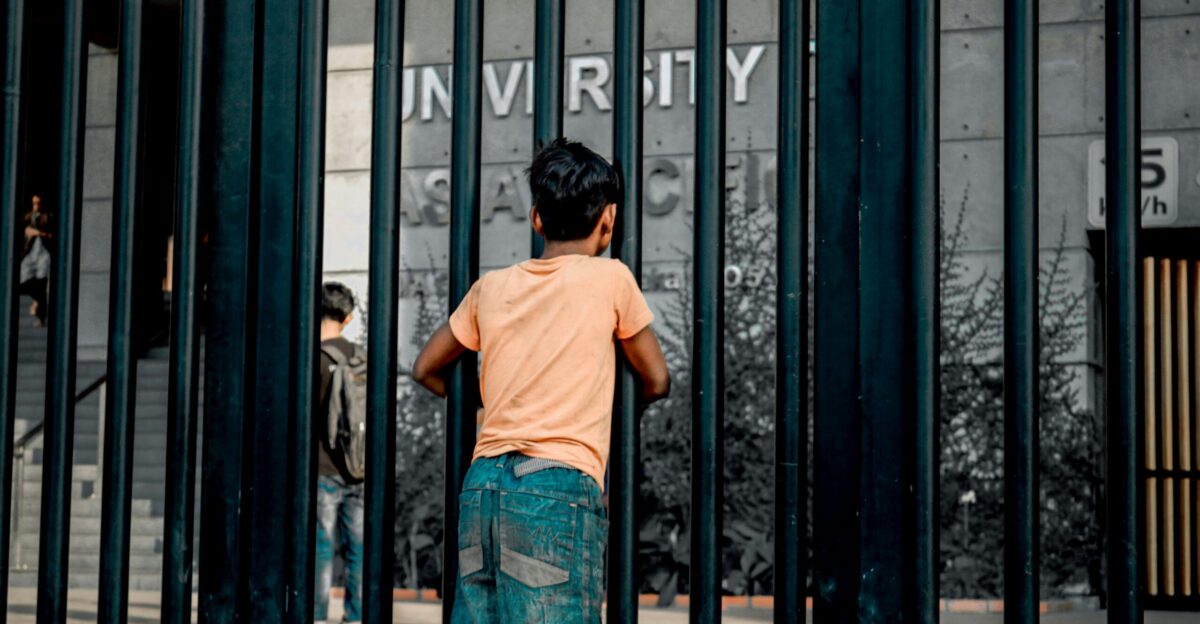 boy standing beside glass building