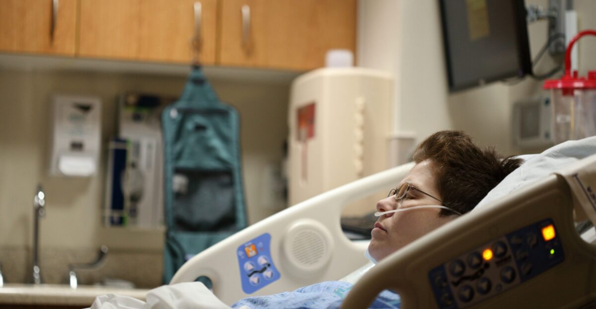 boy lying on beige recliner hospital bed