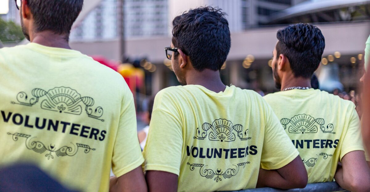 three men wearing yellow Volunteers shirts