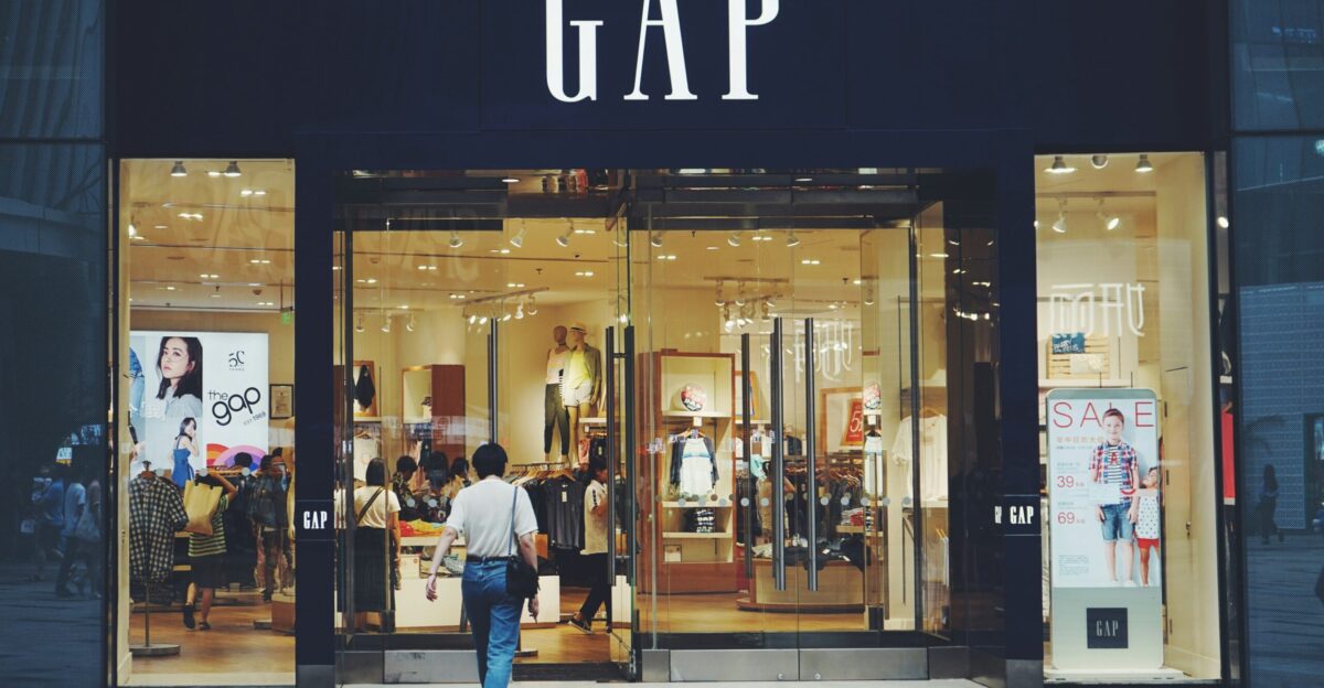 person in white shirt and blue jeans walking inside GAP store