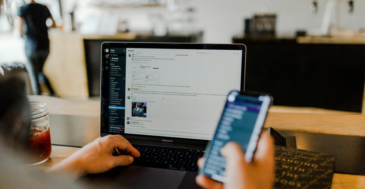 person using phone and laptop