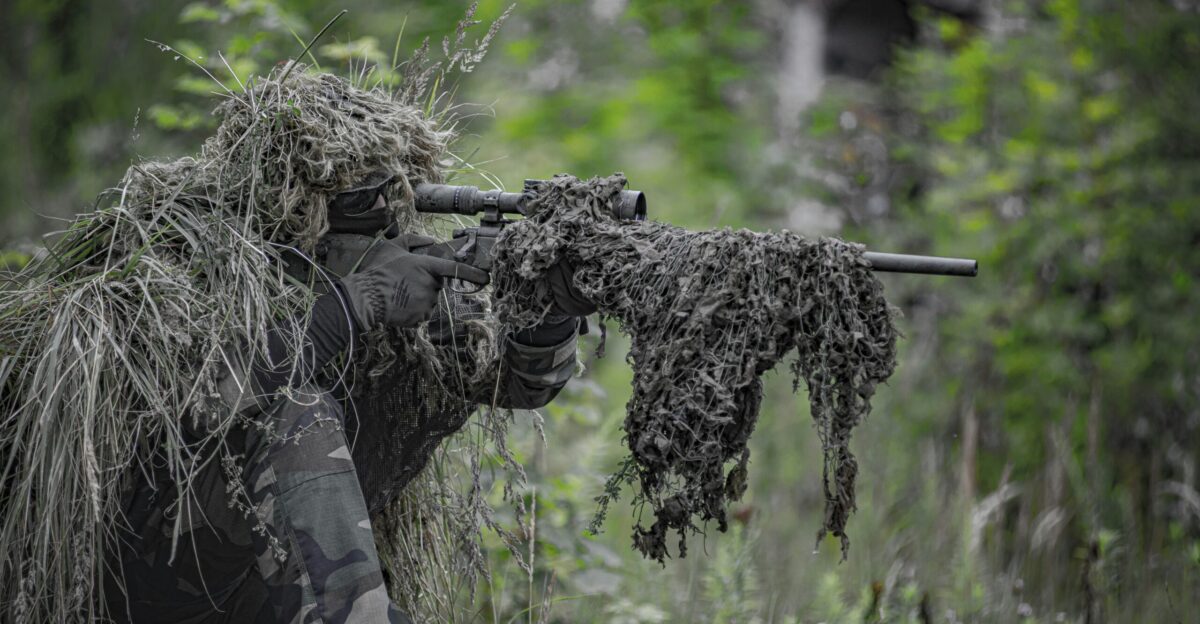 sniper wearing a ghillie in selective focus photography
