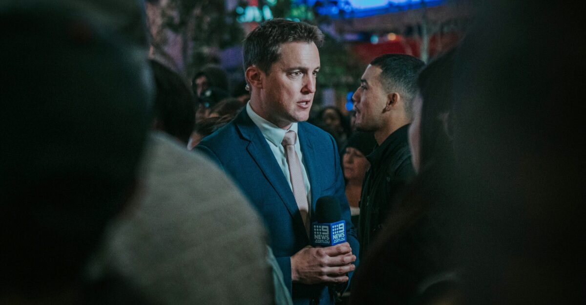 man in black suit standing in front of man in black suit