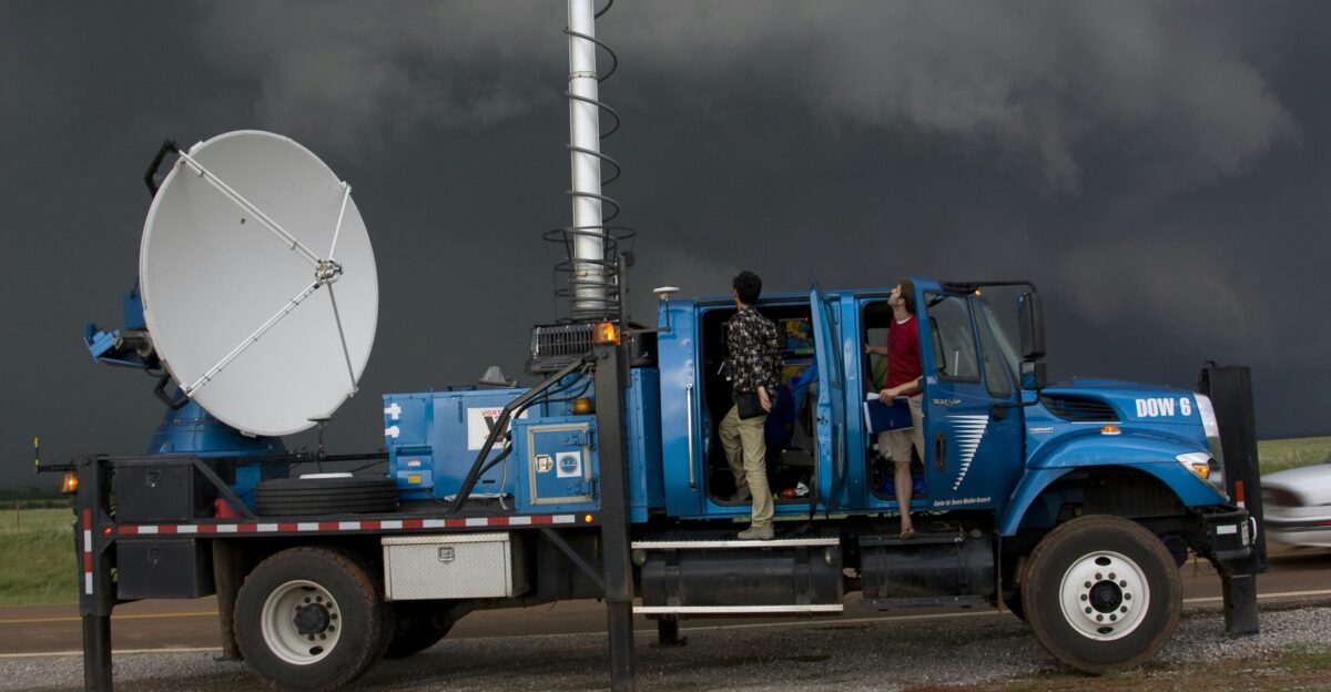 man in blue jacket and blue denim jeans sitting on blue truck