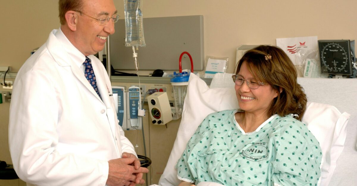 woman in teal scrub suit sitting beside man in white medical scrub suit