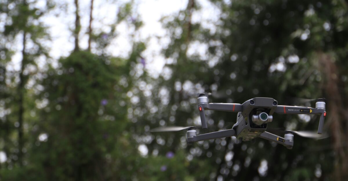 black and white drone flying in mid air during daytime