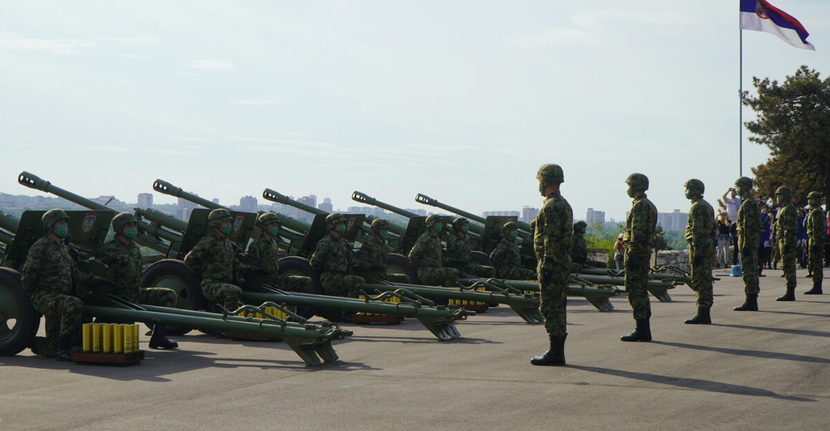 soldiers in green camouflage uniform standing on gray asphalt road during daytime