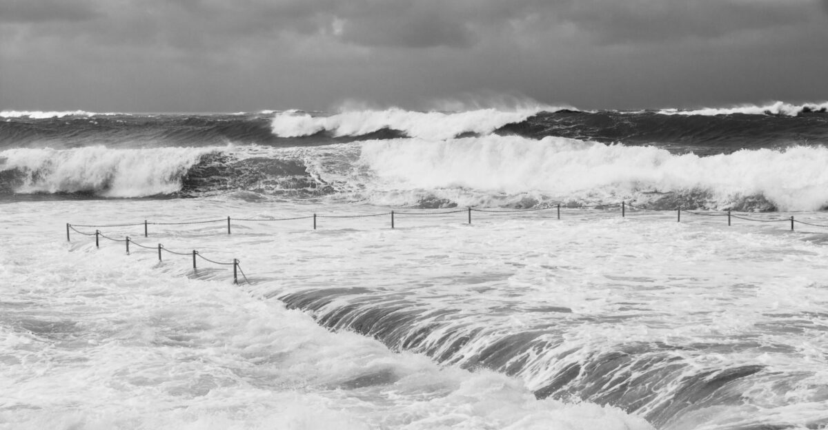 grayscale photo of sea waves crashing on shore