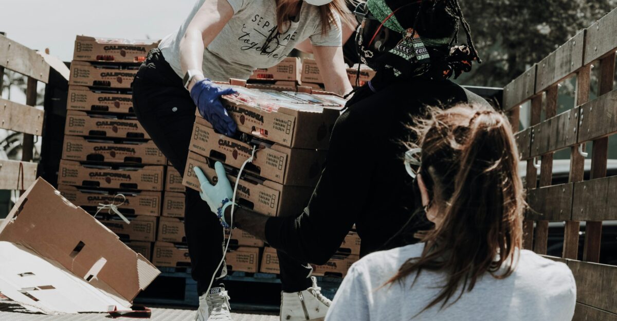 woman in white t-shirt and blue denim jeans sitting on brown cardboard box