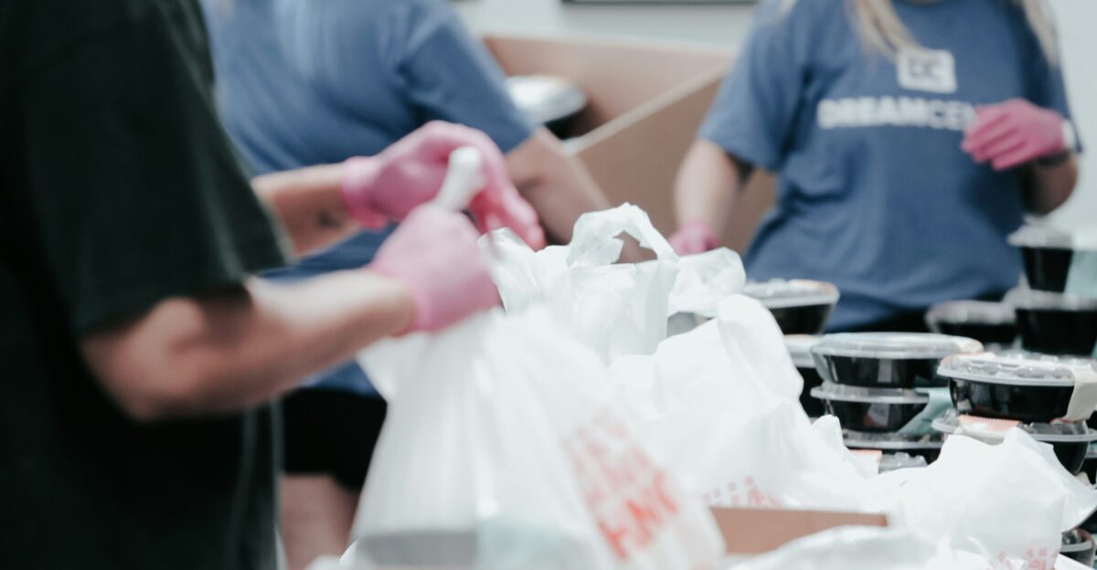 person in blue crew neck t-shirt holding white plastic bag