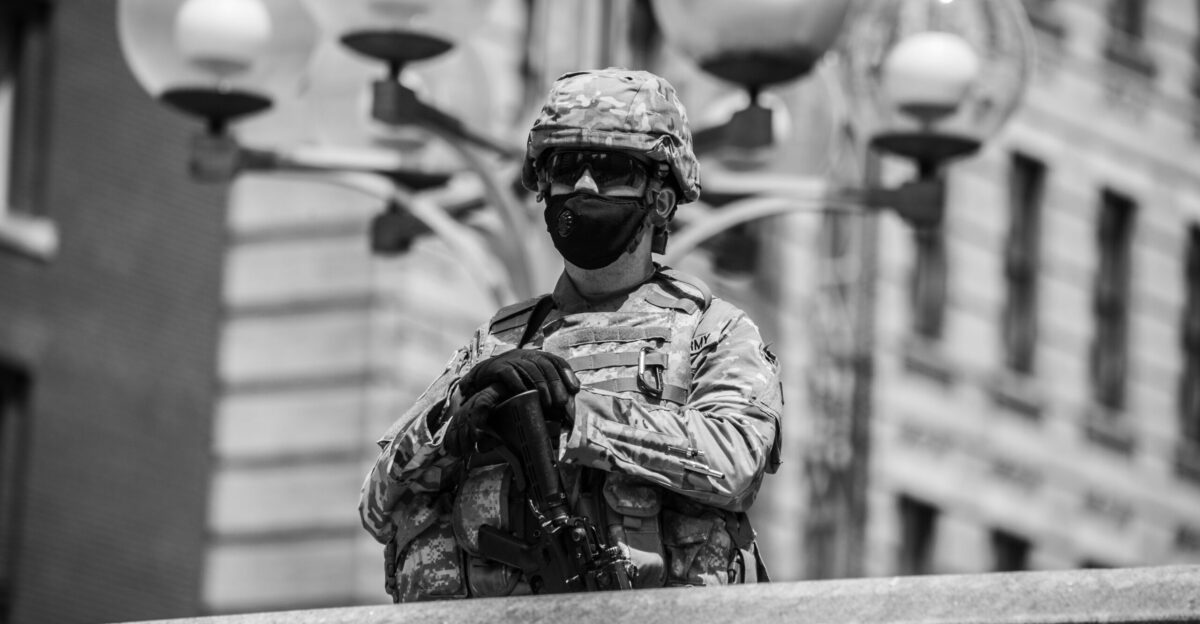grayscale photo of man in camouflage uniform and helmet