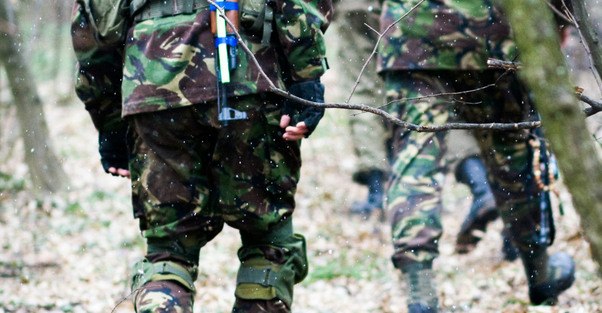 man in green and black camouflage uniform holding rifle