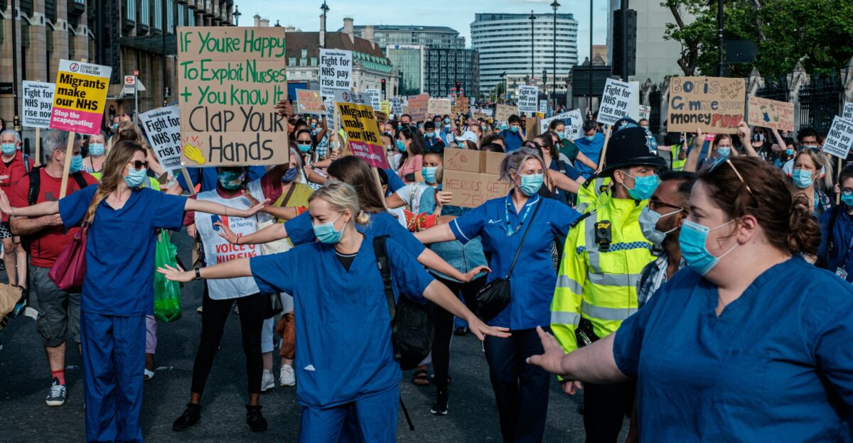 people in blue shirts standing on road during daytime