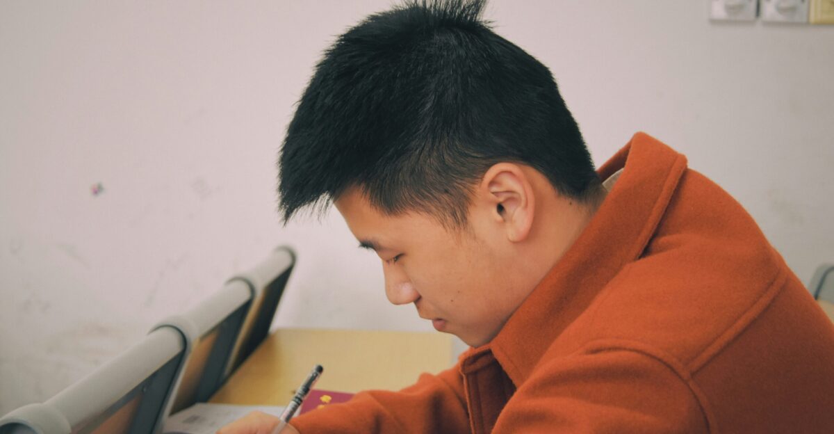 man in orange hoodie using smartphone