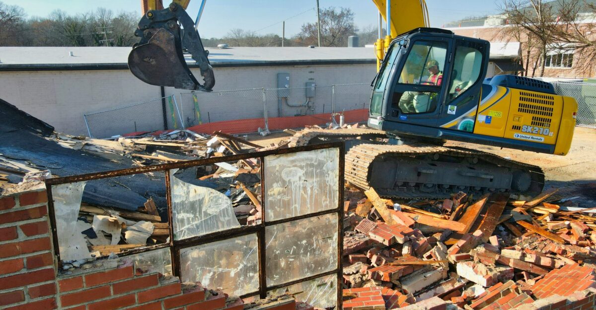 yellow and black excavator on brown brick wall during daytime