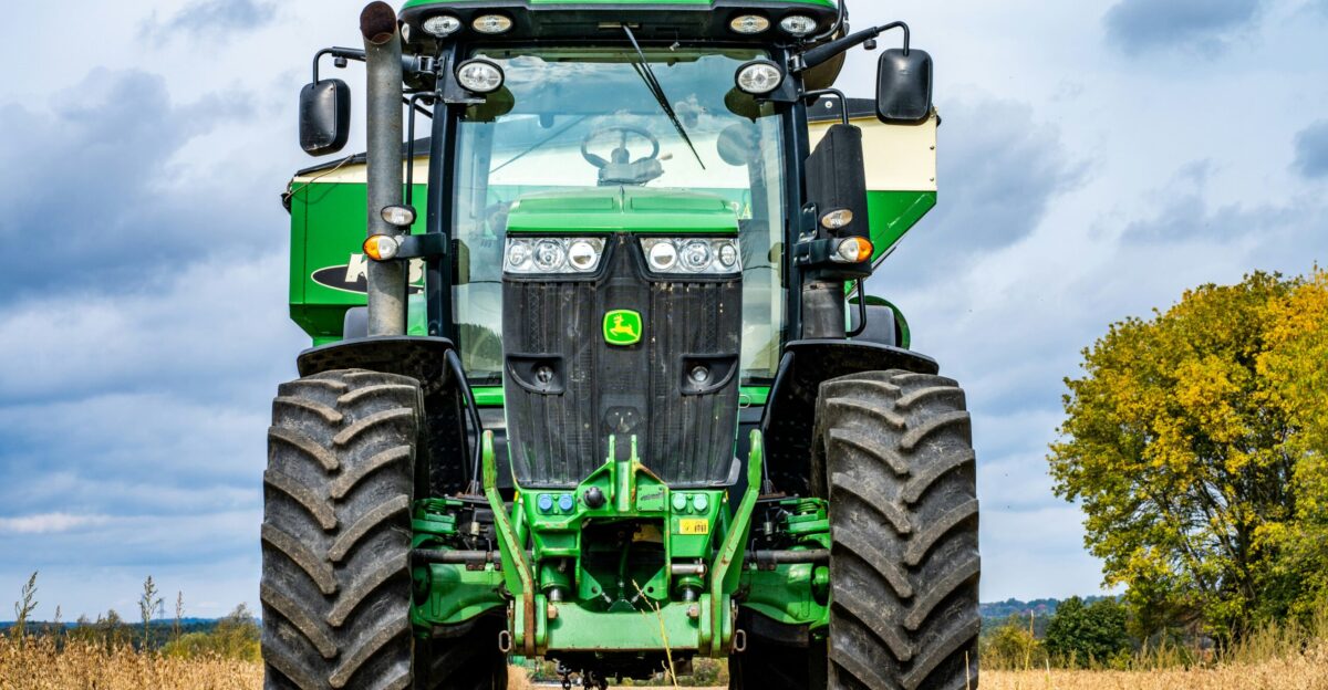green and black tractor on brown grass field during daytime