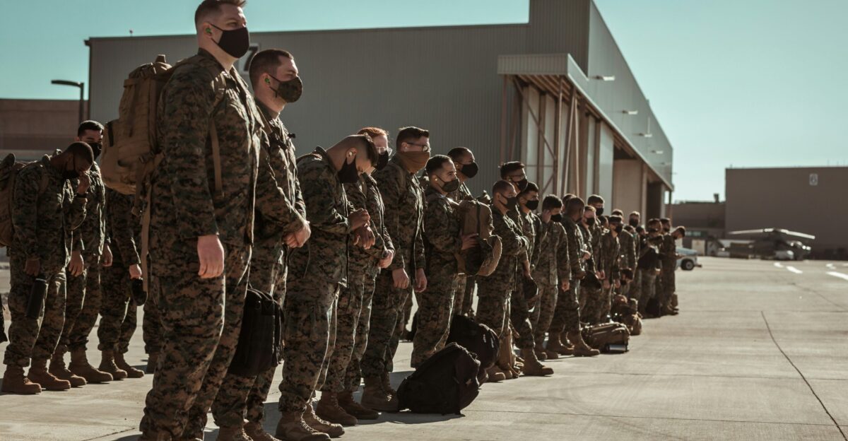 men in black and brown camouflage uniform standing on brown floor