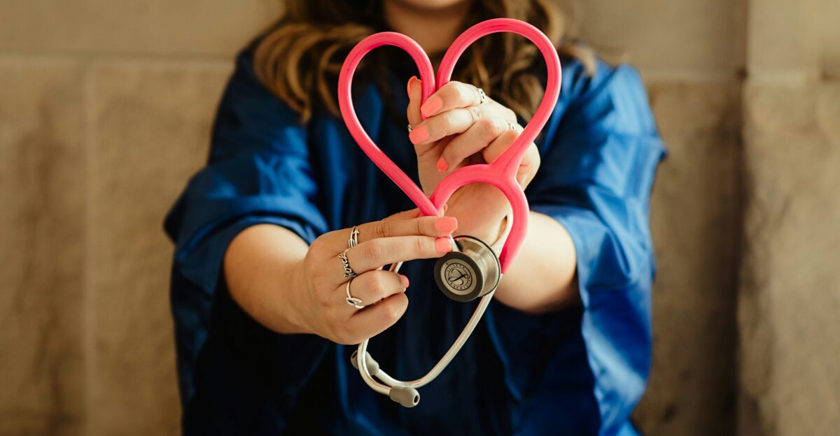 girl in blue jacket holding red and silver ring